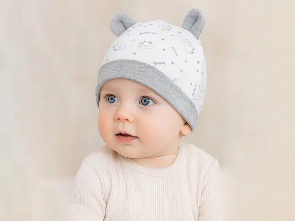 نوزاد با کلاه گوشدار سفید و طوسی